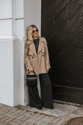 a lady in a brown crop trench coat and a pair of black wide leg pants